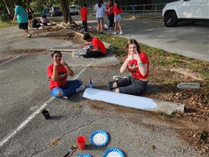 More students painting parking lot dividers.